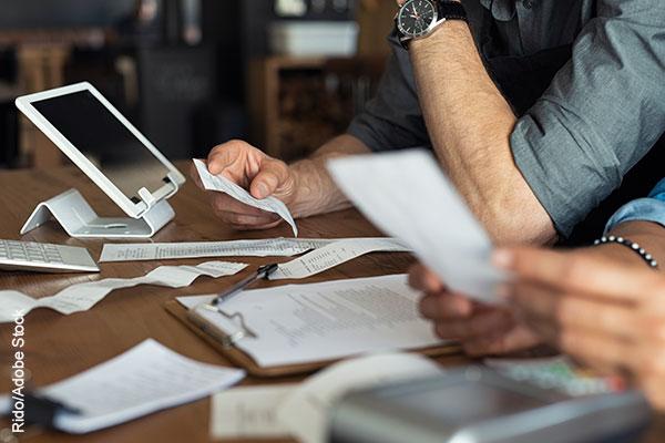 Business owners calculating expenses